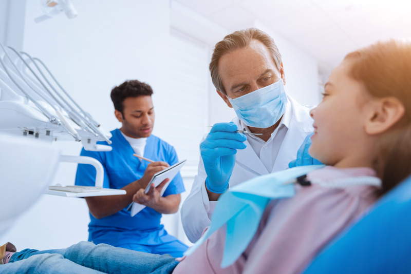 A dentist performing dental check-ups on a patient