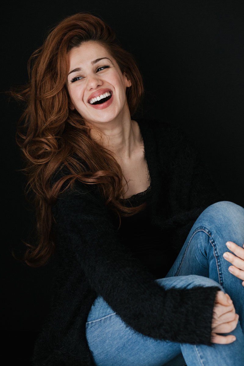 A woman with a beautiful smile posing for a photo, showing people how to get nice white celebrity teeth